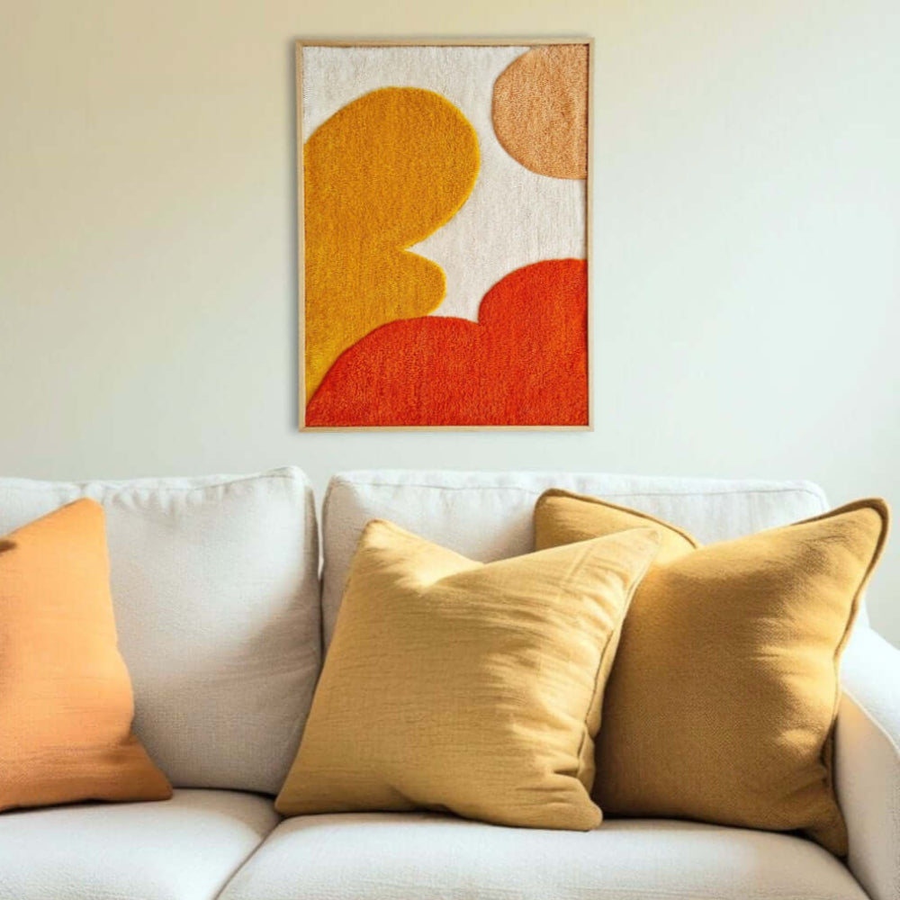 handgetufteter gerahmter Wandteppich mit abstrakten, organischen Formen in orange, kräftigem gelb, melone und beige, unterschiedliche Florhöhen lassen das Bild lebendig wirken, gerahmter Wandteppich über Couch hängend als Eyecatcher und Soundabsorber